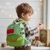 Child wearing a green dinosaur-shaped backpack named David.