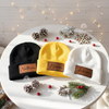 Black, yellow, and white beanies with leather patches named Nathan, Noah, and Julian.