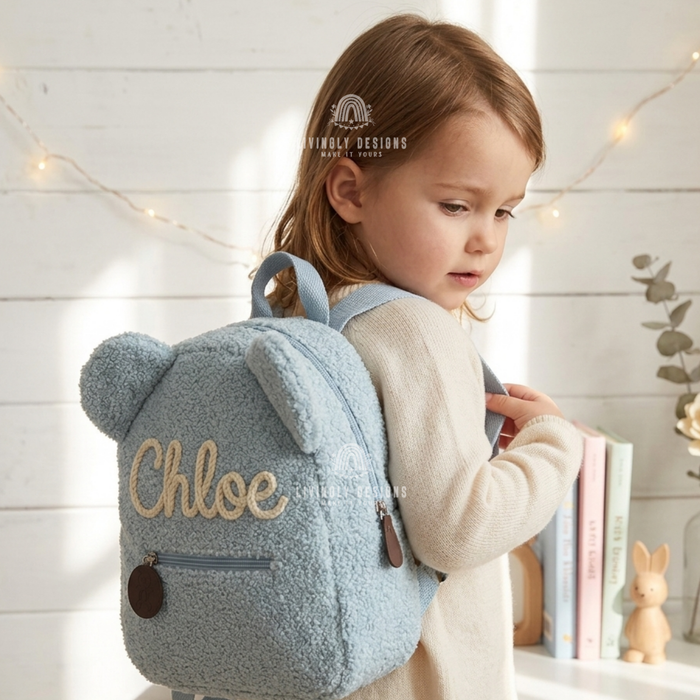 Child wearing a blue teddy bear backpack named Chloe.