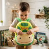 Smiling child holding a green turtle-shaped backpack named Julian.