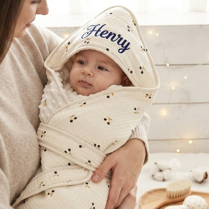 Hooded blanket named Henry, baby held by mother.