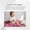 Baby sitting on a pink personalized blanket named Sarah with a "Love It Promise" satisfaction guarantee message.