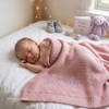 Sleeping baby covered with pink knit blanket named Emily