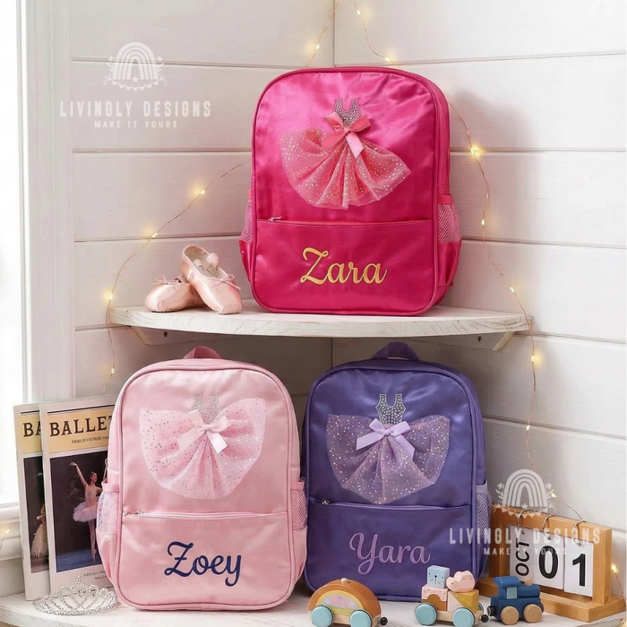 Pink, light pink, and purple backpacks with sparkly tulle ballerina dress appliqués, personalized with the names "Zara," "Zoey," and "Yara," displayed with ballet shoes and a ballet-themed book.