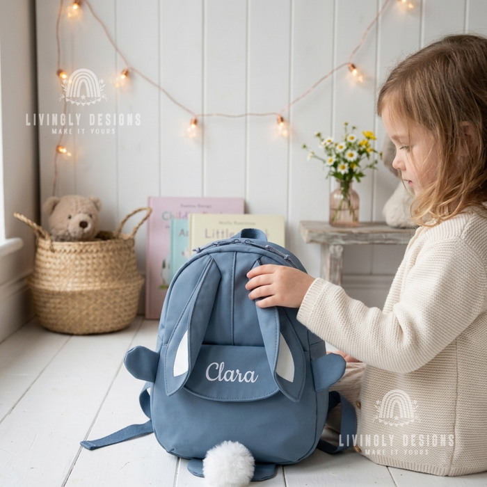 Girl with a blue bunny backpack with the name "Clara"