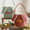 Sage green and terracotta Easter baskets with bunny ears, named Maeve and Arya.