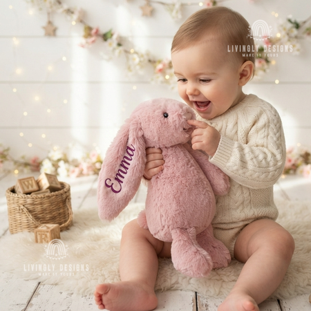 Baby holding a bunny plush named Emma.