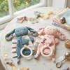 Teal and pink bunny-shaped baby comforters with teething rings, personalized with the names "Steve" and "Amy"