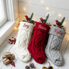 White, red, and gray knit stockings with the names "Ivy," "Tessa," and "Kylie"