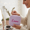 Woman holding lavender corduroy makeup bag personalized with the name Emma
