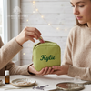 Woman holding green corduroy makeup bag personalized with the name Kylie