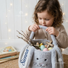 Girl holding grey bunny Easter basket named Sienna