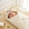 Hooded blanket named Emily, smiling baby.