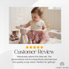Baby wearing a cream knit romper personalized with the name "Eloise"
