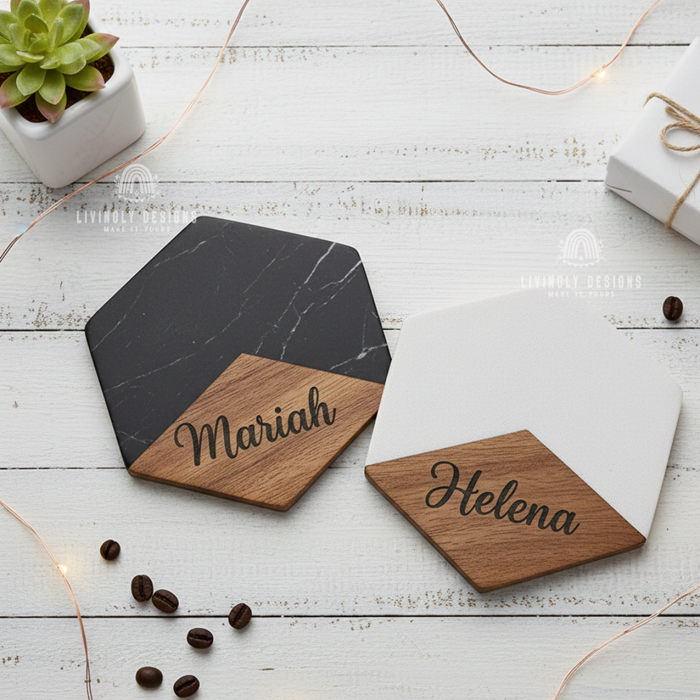 Two hexagonal marble and wood coasters engraved with the names "Mariah" and "Helena," styled on a white wooden surface