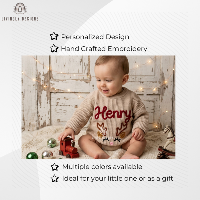 Smiling baby wearing a beige knitted sweater personalized with the name "Henry" and an embroidered reindeer face design, playing with a wooden toy train.
