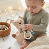 Baby holding a beige fox-shaped comforter with a teething ring, personalized with the name "Silas"