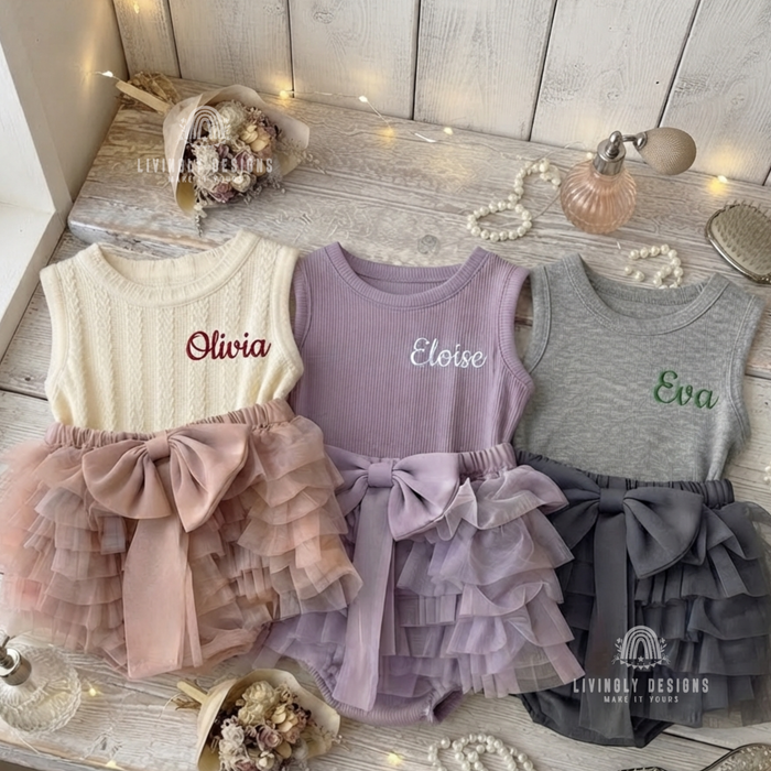 Cream, purple, and gray tank-top rompers with ruffled tutu bottoms and bows, personalized with the names "Olivia," "Eloise," and "Eva"