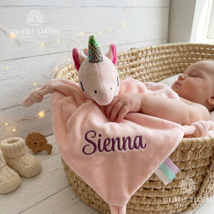Sleeping baby with pink unicorn security blanket named Sienna